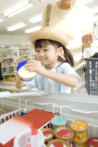 コンビニでアイスを選ぶ麦わら帽子をかぶった女の子