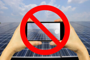 左右の手で支えられるスマートフォンの上に禁止の赤いマーク