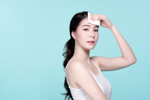 コットンをおでこにあてる素肌の女性