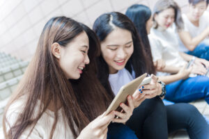 タブレットを見ながら談笑する女性たち