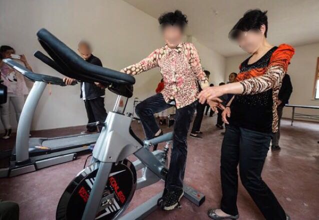 トレーニングマシンにまたがり会話を楽しむ初老の女性