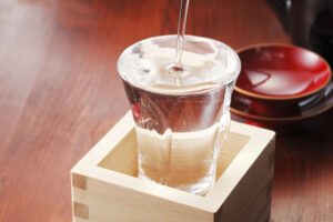 マスに入ったコップからあふれる日本酒