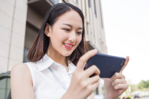 スマホをのぞき込むノースリーブの女性