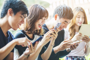 スマホをのぞき込む若者たち