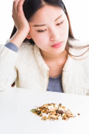 生薬とうつむく女性